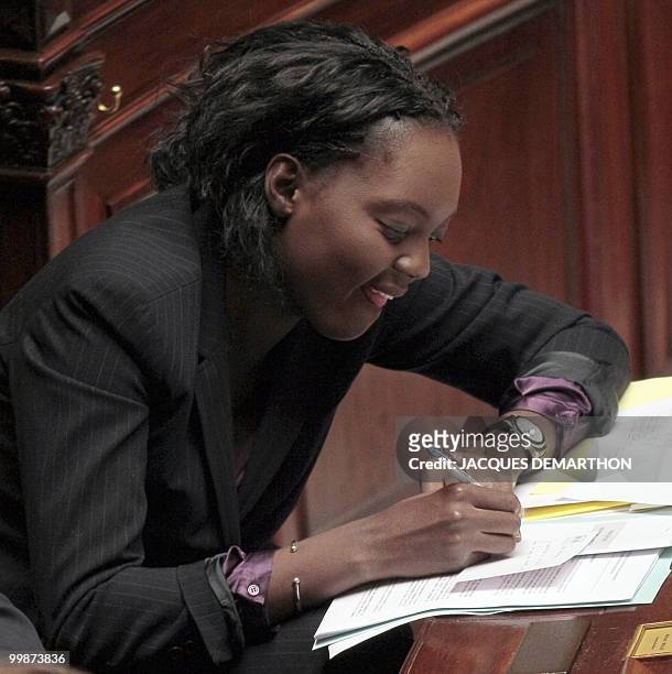 France's Junior Minister for Sports Rama Yade writes during the weekly session of questions to the government on May 18, 2010 at the national...
