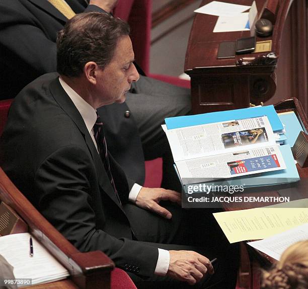 France's Imigration Minister Eric Besson reads during the weekly session of questions to the government on May 18, 2010 at the national assembly in...