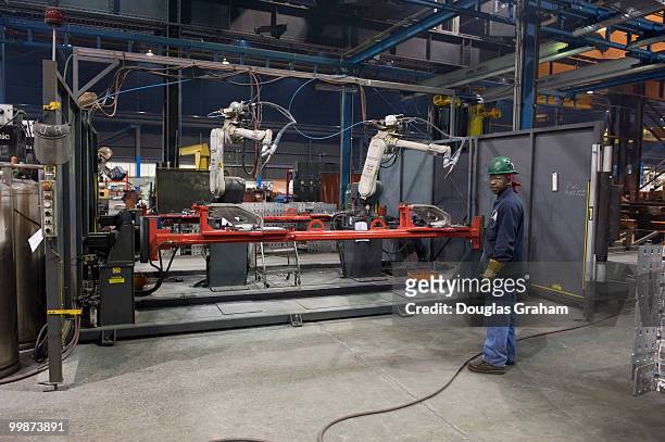 Worker welds parts using a robotic welder at JWF Defense Systems in Johnstown Pennsylvania. JWF Defense Systems is a small business located in...