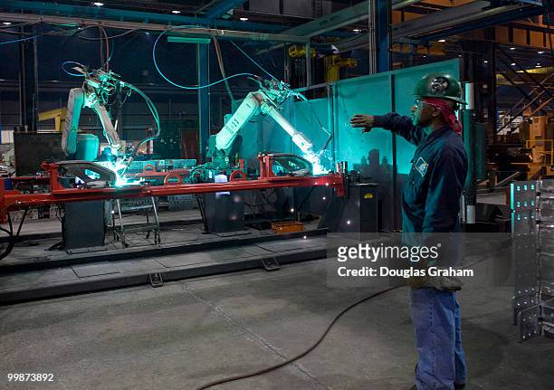 Worker welds parts using a robotic welder at JWF Defense Systems in Johnstown Pennsylvania. JWF Defense Systems is a small business located in...