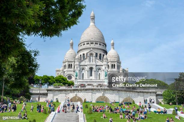 people sunbathing next to sacre-coeur basilica, montmartre, paris, france - coeur fotografías e imágenes de stock