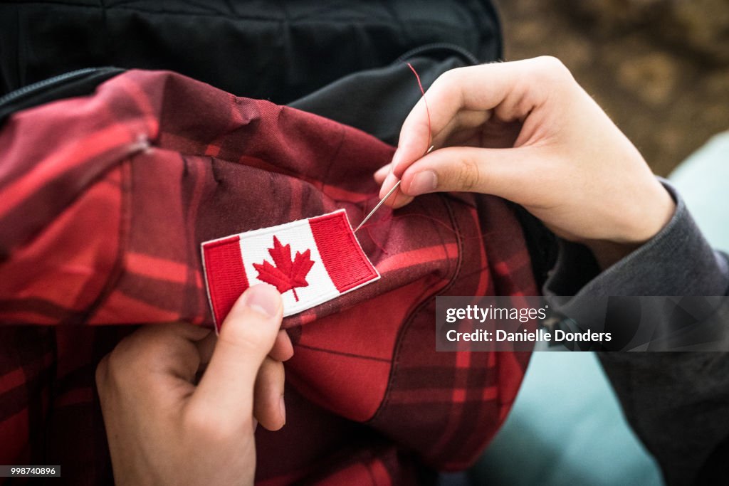 Sewing a Canadian flag onto a backpack for international travel