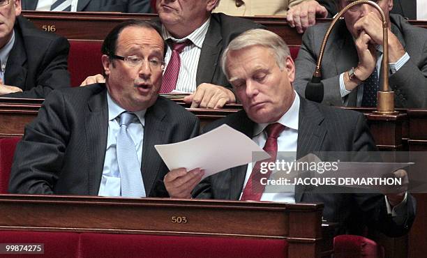 French socialist deputy Francois Hollande speaks with head of French PS group at the national Assembly Jean-Marc Ayrault during the weekly session of...