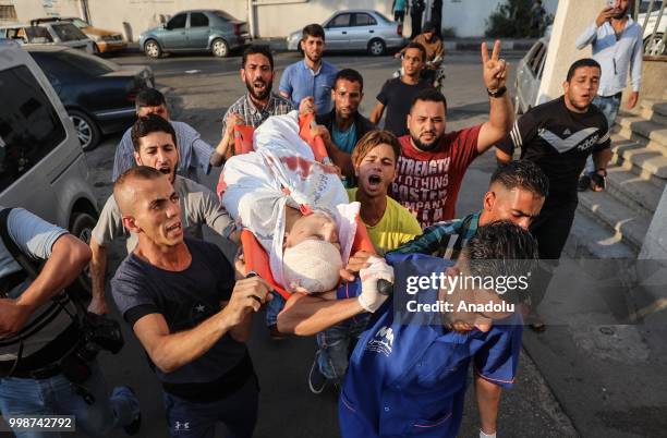 Dead body of a Palestinian is being taken to al-Shifa hospital's morgue after Israeli fighter jets pounded Al Katiba region in Gaza City, Gaza on...