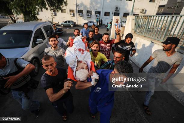 Dead body of a Palestinian is being taken to al-Shifa hospital's morgue after Israeli fighter jets pounded Al Katiba region in Gaza City, Gaza on...