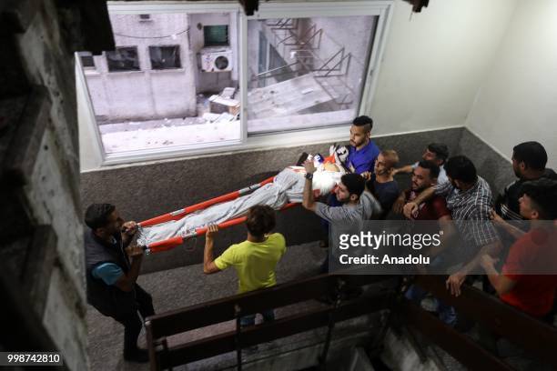 Dead body of a Palestinian is being taken to al-Shifa hospital's morgue after Israeli fighter jets pounded Al Katiba region in Gaza City, Gaza on...