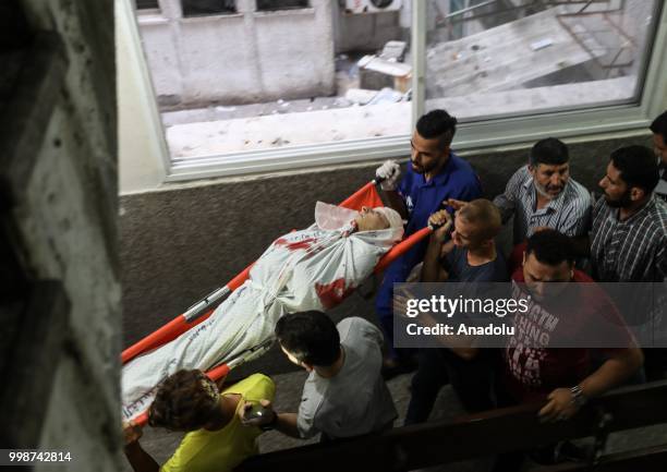 Dead body of a Palestinian is being taken to al-Shifa hospital's morgue after Israeli fighter jets pounded Al Katiba region in Gaza City, Gaza on...