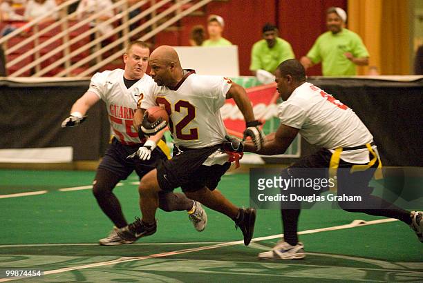 Ricky Ervins of the Washington Redskins scoots past Bill Scofiels and Spencer Wilson during the Roll Call Longest Yard Football Classic charity...