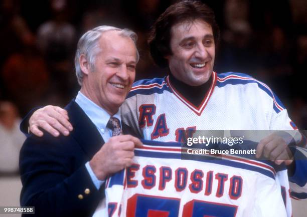 Former NHL player Gordie Howe presents Phil Esposito of the New York Rangers a jersey as Esposito retires after an NHL game against the Buffalo...