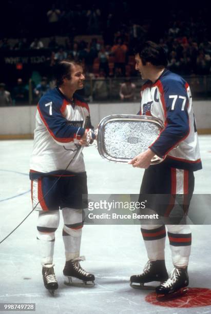 Phil Esposito of the New York Rangers receives a silver plate from teammate Rod Gilbert prior to an NHL game circa April, 1977 at the Madison Square...