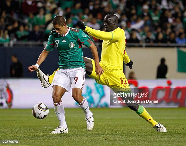 Javier Hernandez of Mexico tries to set up a shot under pressure from Ferdinand Gomis of Senegal during an international friendly at Soldier Field on...