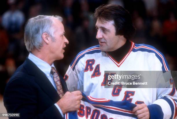 Former NHL player Gordie Howe presents Phil Esposito of the New York Rangers a jersey as Esposito retires after an NHL game against the Buffalo...