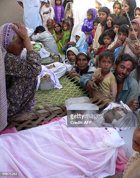 Pakistan relatives mourn over the bodies of blast victims following a bomb attack in Dera Ismail Khan on May 18, 2010. A bomb planted on a bicycle...