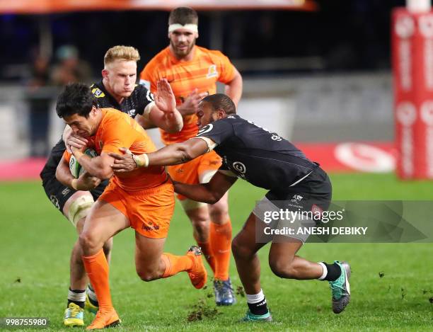 Sharks' eight man Daniel du Preez and centre Lukhanyo Am tackle Jaguares' centre Matais Morni during the Super Rugby match between the Sharks and the...