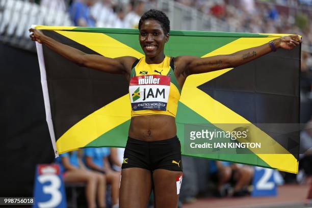 Jamaica's Janieve Russell celebrates with the Jamaican flag after winning the women's 400m hurdles during the Athletics World Cup team competition at...