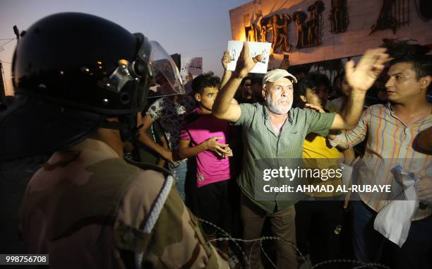 Member of the Iraqi security forces stands guard as protesters in the capital Baghdad's Tahrir Square demonstrate against unemployment on July 14,...