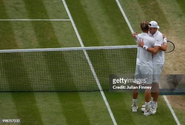Kevin Anderson of South Africa hugs John Isner of The United States after their Men's Singles semi-final match on day eleven of the Wimbledon Lawn...