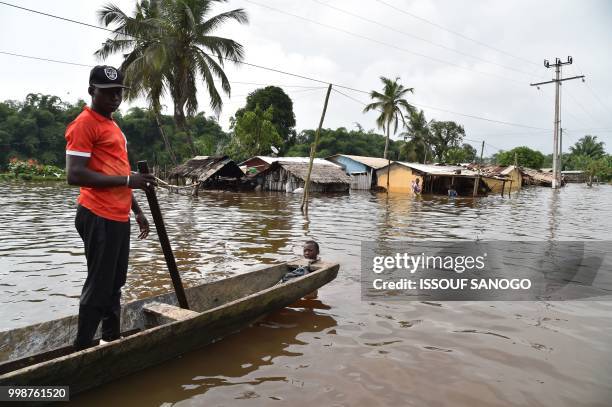 This picture taken on July 14, 2018 shows a man walking in a flooded area in Aboisso, 120 kms from Abidjan after a heavy rainfall.