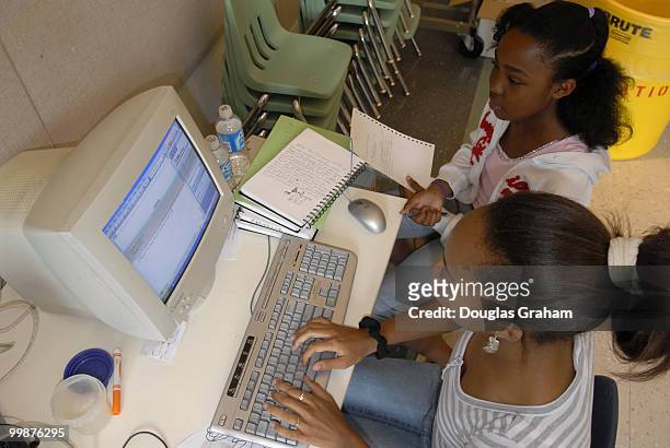 Ariel Woolfolk and Janelle Anderson work on captions for their photo project being displayed at the National Building Museum, "Investigating Where We...