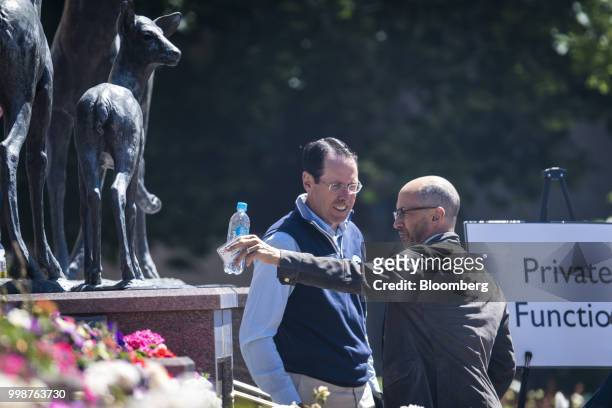 Randall Stephenson, chairman and chief executive officer of AT&T Inc., left, speaks with Dick Costolo, former chief executive officer of Twitter...