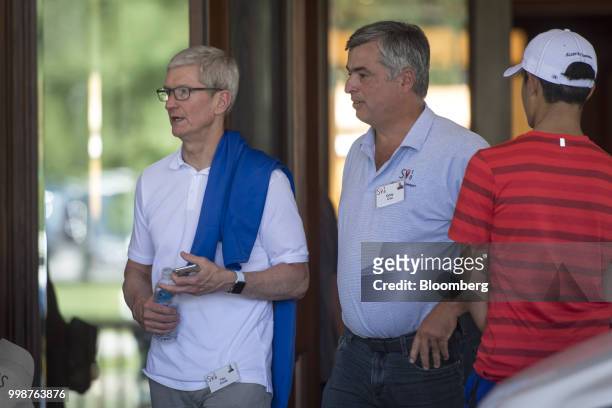 Tim Cook, chief executive officer of Apple Inc., left, and Eddy Cue, senior vice president of internet software and services at Apple Inc., exit the...
