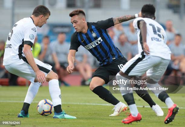 Lautaro Martinez of FC Internazionale is challenged by Eloge Yao and Vladimir Golemic of FC Lugano during the pre-season friendly match between...