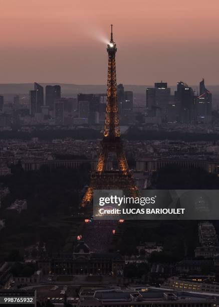 This picture taken from the panoramic observatory of the Montparnasse Tower shows the sunset over Paris and the Eiffel Tower on July 14 few hours...