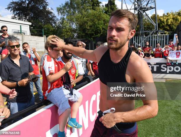 Aaron Ramsey of Arsenal gives his shirt to a fan after the match between Borehamwood and Arsenal at Meadow Park on July 14, 2018 in Borehamwood,...