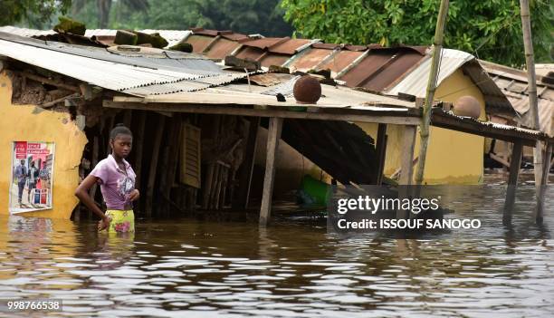 This picture taken on July 14, 2018 shows a girl walking in a flooded area in Aboisso, 120 kms from Abidjan after a heavy rainfall.