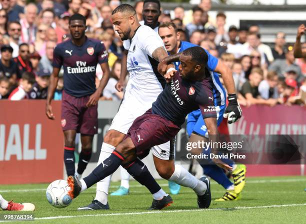 Alexandre Lacazette of Arsenal competes for the ball against David Stephens of Borehamwood during the match between Borehamwood and Arsenal at Meadow...