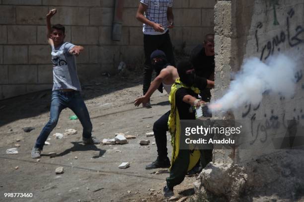 Palestinians throw rocks in response to Israeli security forces intervention as they stage a protest after the funeral of Rami Sabarine, who was...