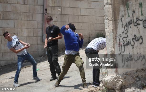 Palestinians throw rocks in response to Israeli security forces intervention as they stage a protest after the funeral of Rami Sabarine, who was...