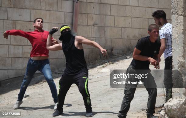 Palestinians throw rocks in response to Israeli security forces intervention as they stage a protest after the funeral of Rami Sabarine, who was...