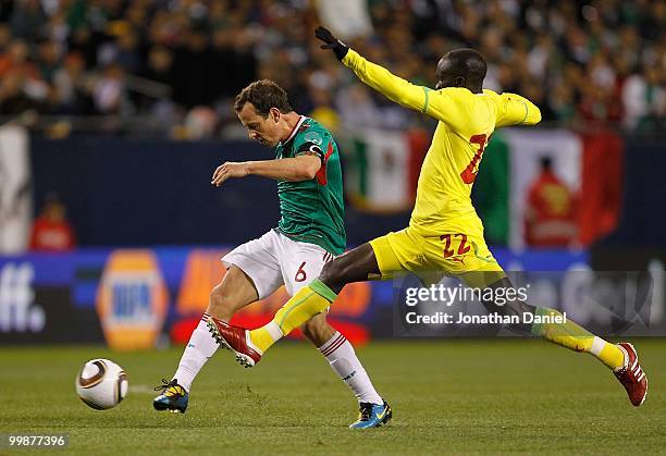 Gerardo Torrado of Mexico passes the ball under pressure from Pape Alioune of Senegal during an international friendly at Soldier Field on May 10,...