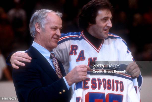 Former NHL player Gordie Howe presents Phil Esposito of the New York Rangers a jersey as Esposito retires after an NHL game against the Buffalo...