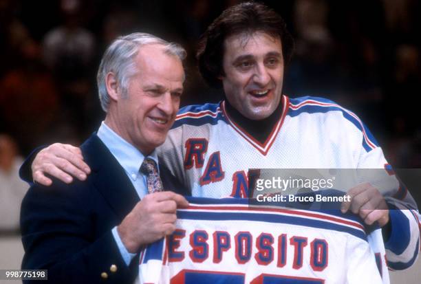 Former NHL player Gordie Howe presents Phil Esposito of the New York Rangers a jersey as Esposito retires after an NHL game against the Buffalo...