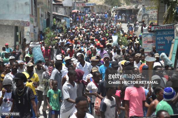 Demonstrators marched through the streets of Port-au-Prince, on July 14, 2018 to protest against the government of President Jovenel Moise and...