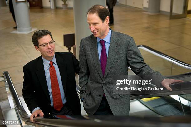 Sam Brownback, R-KS and Ron Wyden, D-OR., talk on the way to the first vote of the day during the Saturday work session on the health care bill,...