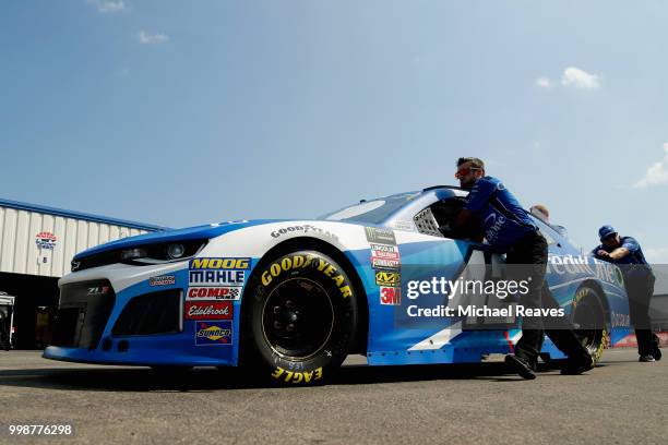 Crew members push the car of Kyle Larson, driver of the Credit One Bank Chevrolet, through the garage area prior to the Monster Energy NASCAR Cup...