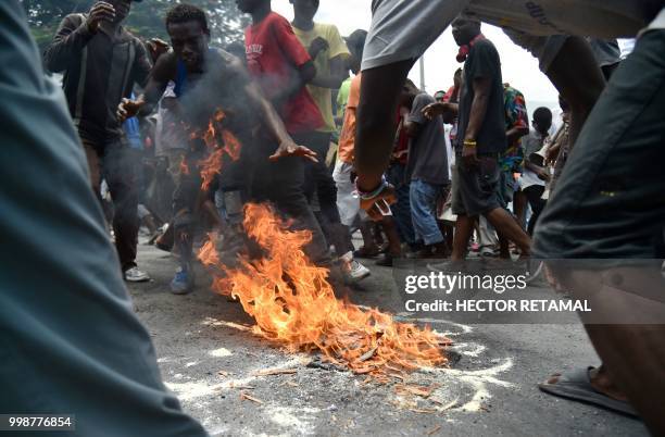 Demonstrators perform a voodoo ceremony during a march through the streets of Port-au-Prince, on July 14, 2018 to protest against the government of...