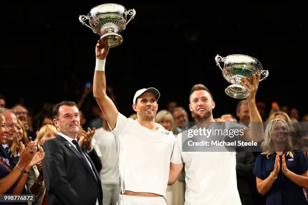 Mike Bryan and Jack Sock of The United States lift their trophies as they celebrate their victory against Raven Klaasen of South Africa and Michael...