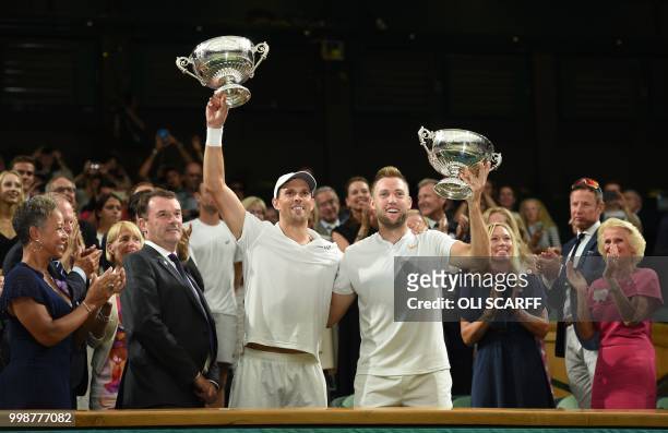 Players Mike Bryan and Jack Sock hold up their trophies after beating South Africa's Raven Klaasen and New Zealand's Michael Venus 6-3, 7-6, 6-3,...