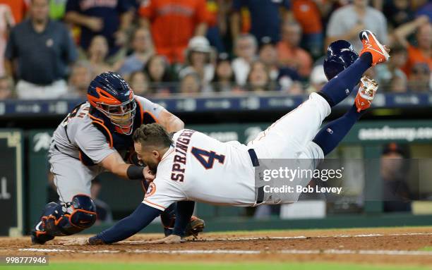 George Springer of the Houston Astros is tagged out by James McCann of the Detroit Tigers attempting to score in the second inning on a single by...