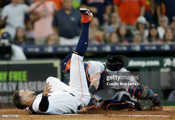 George Springer of the Houston Astros is tagged out by James McCann of the Detroit Tigers attempting to score in the second inning on a single by...