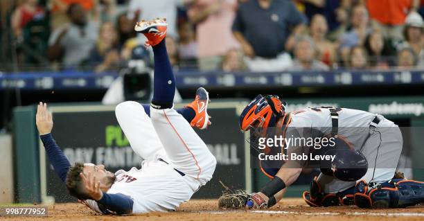 George Springer of the Houston Astros is tagged out by James McCann of the Detroit Tigers attempting to score in the second inning on a single by...