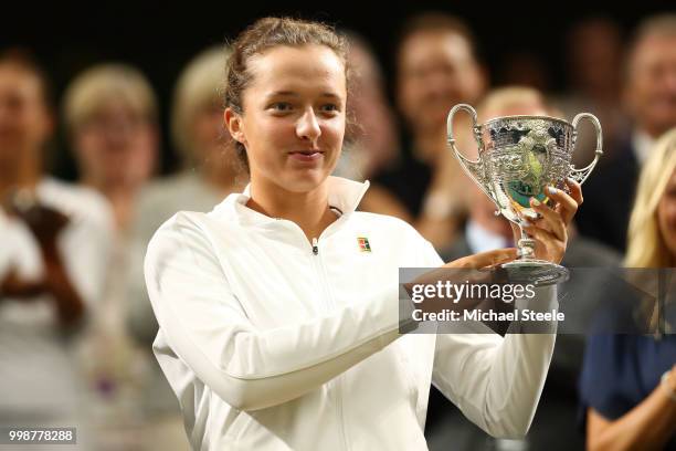 Iga Swiatek of Poland, winner of the Girls' Singles final poses with her trophy in Centre Court on day twelve of the Wimbledon Lawn Tennis...