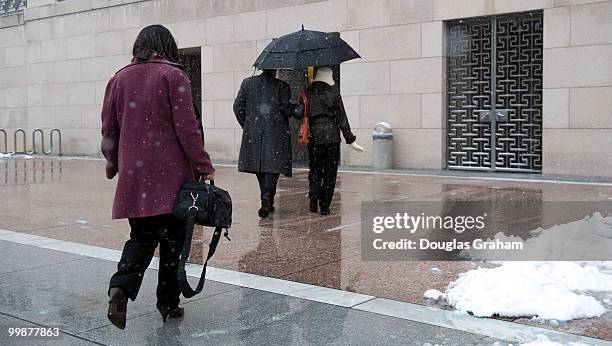 People walk into the Rayburn House Office Building and out of the first snow fall of the year on Capitol Hill in Washington, D.C. , January 27, 2009.