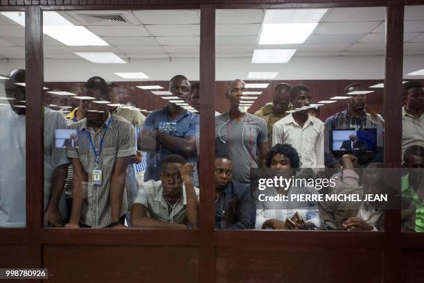 Group of individuals watching the speech of Prime Minister Jack Guy Lafontant through the window from outside the room of the Chamber of Deputies in...