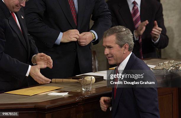 George w. Bush smiles after knocking over Cheney's water after his State of the Union address.