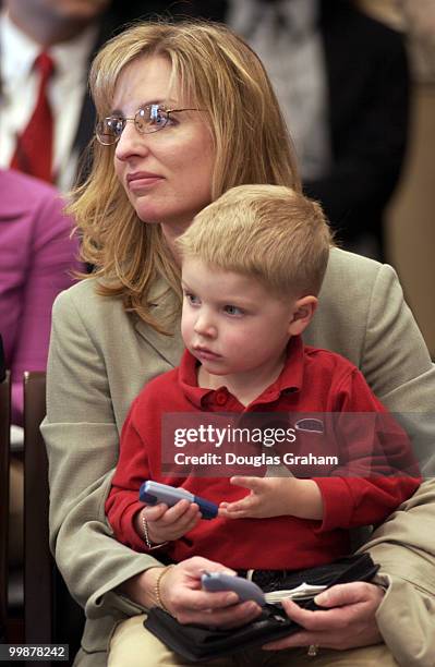 Zachary Hershey, age 3, seated on his mother Lori's lap checks his blood suger during news conference to urge President Bush to expand the federal...